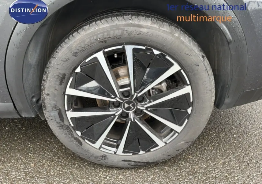 Gros plan sur la jante biton noire et argent du côté arrière droit du DS7 gris titane métal 2024.
