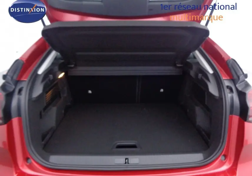 Coffre ouvert vu de l'arrière d'une Citroën C4 2023 rouge Elixir Metal, montrant un espace de chargement vide.