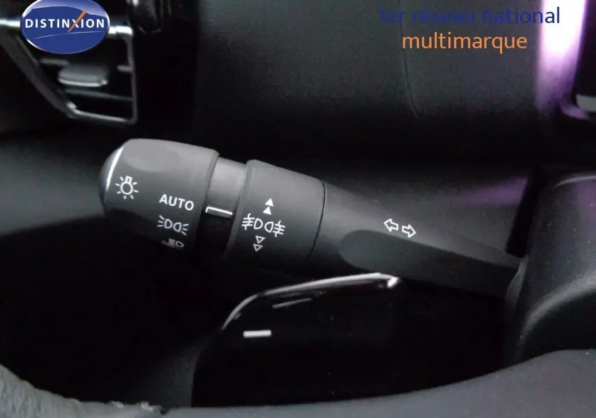 Gros plan sur la commande des feux et clignotants à gauche du volant d'une Citroën C4 rouge Elixir Metal 2023.