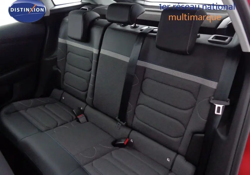 Vue intérieure sur la banquette arrière en tissu gris avec ceintures noires d'une Citroën C4 rouge Elixir 2023.