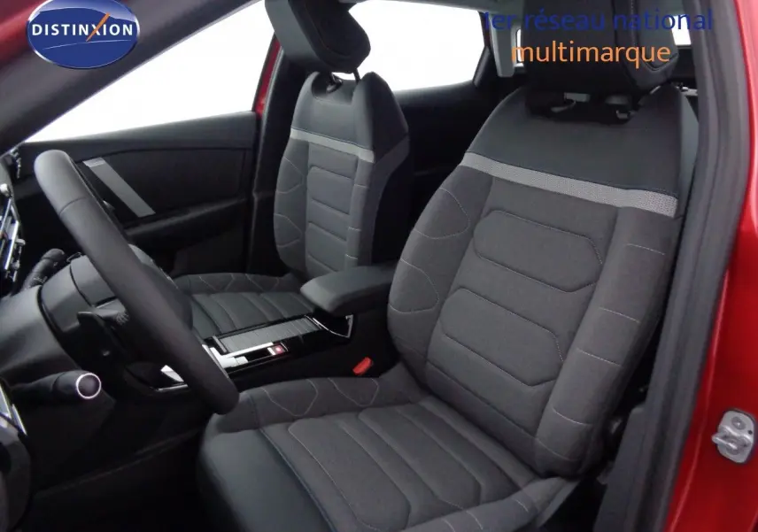 Vue intérieure côté conducteur de la Citroën C4 rouge Elixir Metal, sièges tissu gris et volant multifonction.