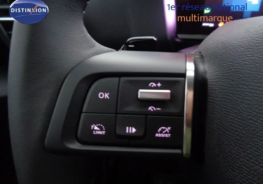 Gros plan sur les commandes au volant côté gauche de la Citroën C4 2023 en rouge Elixir Metal, boutons de régulateur et limiteur.