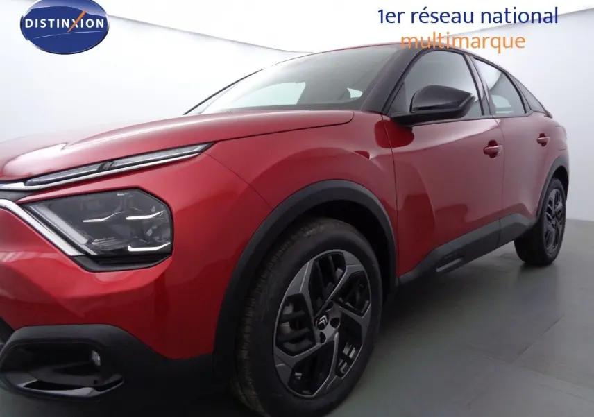 Vue 3/4 avant droit d'une Citroën C4 rouge Elixir métal avec jantes alliage et détails noirs contrastants.