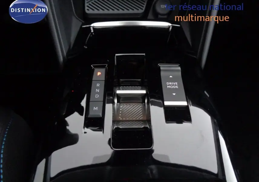 Gros plan sur la console centrale noire brillante de la Citroën C4 2023 avec sélecteur de boîte auto et bouton Drive Mode.