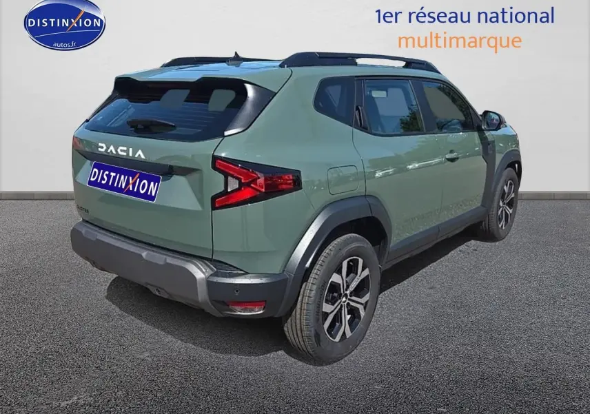 Vue 3/4 arrière droite d'un Dacia Duster 2025 vert kaki avec jantes alu et barres de toit noires.