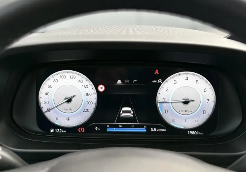 Vue du tableau de bord numérique de la Hyundai i20 2025, affichant vitesse, régime moteur et aides à la conduite.