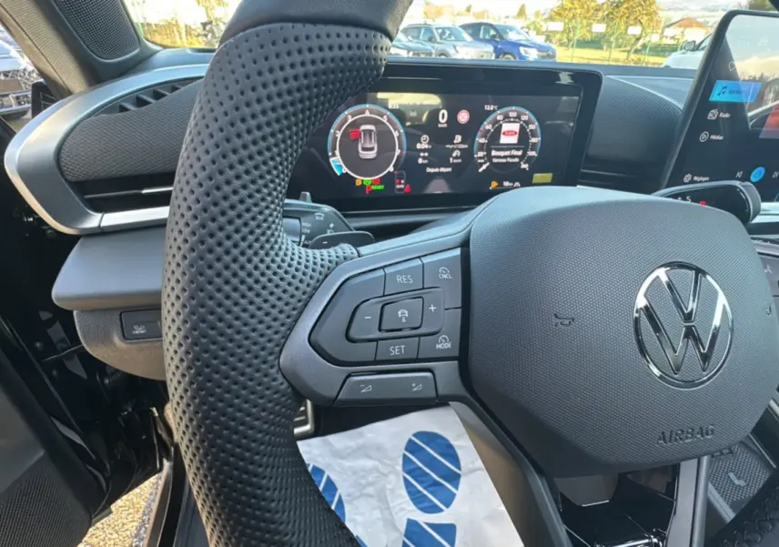 Vue rapprochée du volant multifonctions en cuir perforé et du tableau de bord numérique du Volkswagen T-Roc noir ebène 2026.