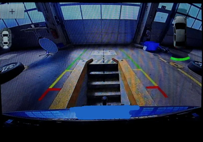 Vue caméra de recul du Ford Kuga bleu azur 2024, avec lignes de guidage colorées et affichage 360° du véhicule.