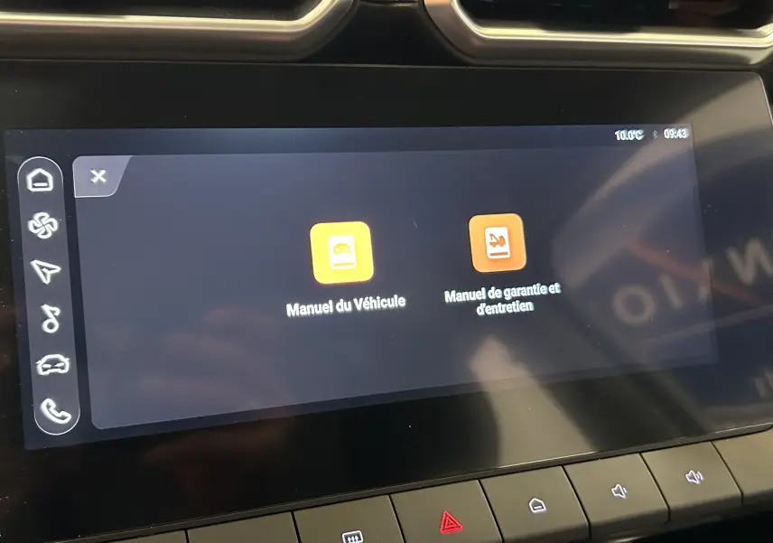 Écran tactile central affichant les manuels du véhicule et de garantie dans un MG ZS Hybrid+ 2025, intérieur noir.