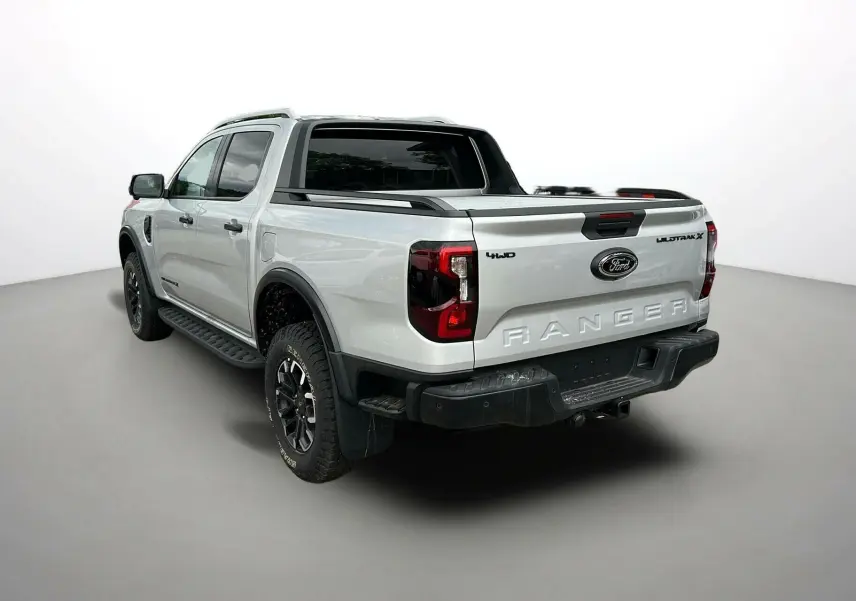 Ford Ranger 2025 gris iconic en 3/4 arrière droit, avec arceau sport, jantes noires et benne ouverte.