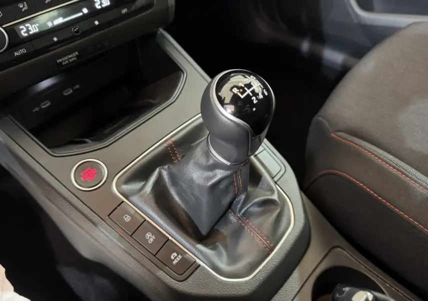 Le levier de vitesses manuel noir avec coutures rouges dans l’habitacle de la SEAT Ibiza 1.0 TSI 110 FR rouge.
