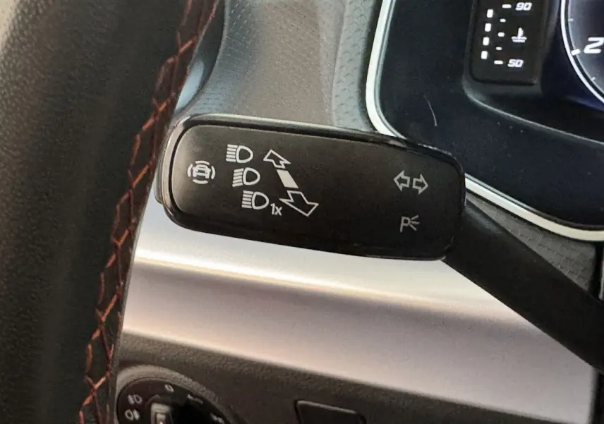 Gros plan sur la commande des phares et clignotants du tableau de bord d’une SEAT Ibiza 1.0 TSI 110 FR rouge 2024.