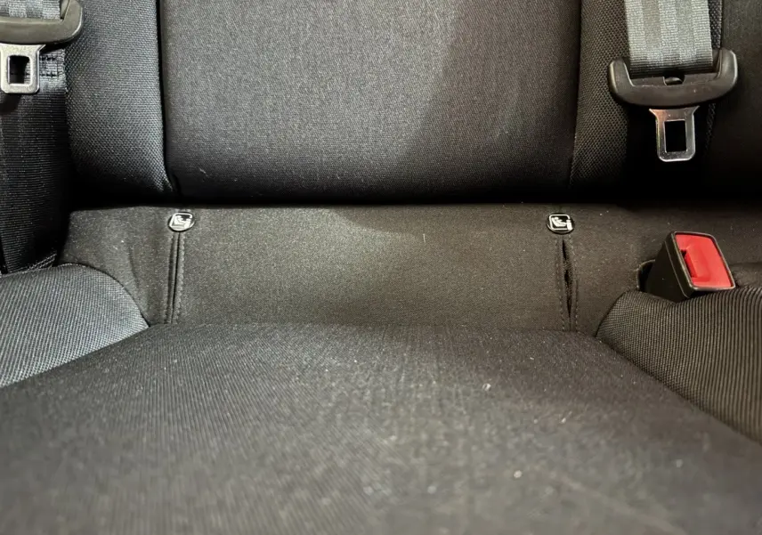 Gros plan sur la banquette arrière noire du SEAT Ibiza 2024, montrant les attaches Isofix et la ceinture de sécurité.