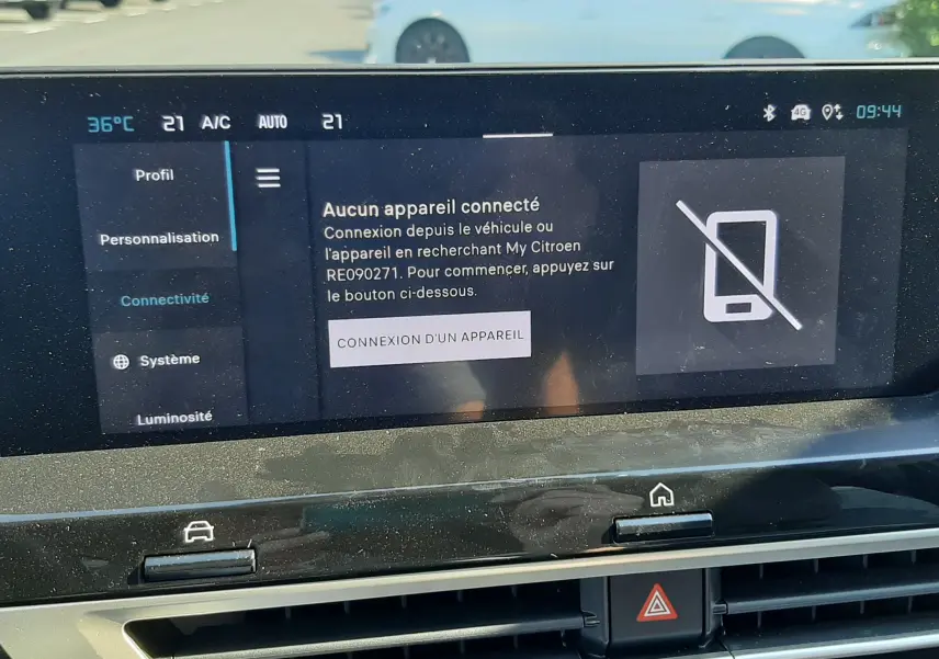 Vue rapprochée de l'écran tactile du tableau de bord du Citroën C4 blanc Okenite, affichant le menu de connectivité.