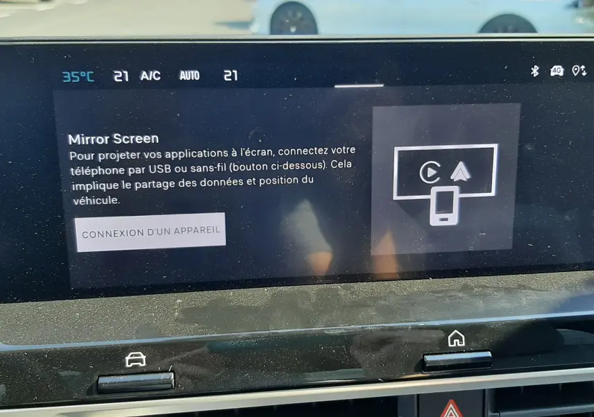 Écran tactile du tableau de bord de la Citroën C4 blanche, affichant l'interface Mirror Screen en intérieur.