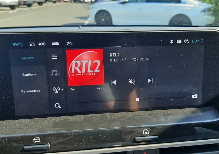 Vue intérieure du tableau de bord de la Citroën C4 1.2 Hybrid 145ch, écran tactile affichant la radio RTL2.