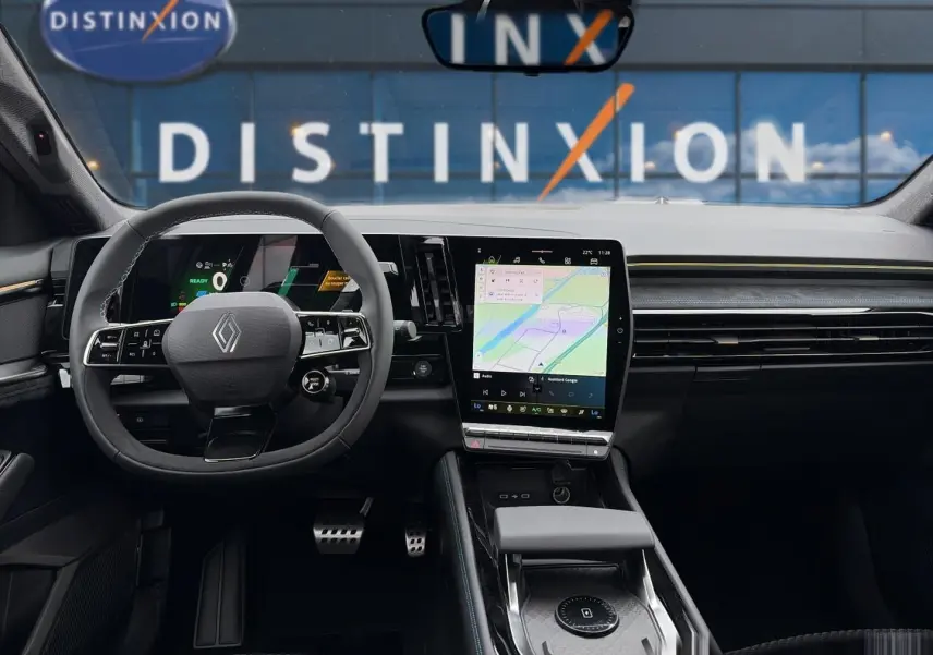 Vue intérieure frontale du Renault Austral gris schiste, avec volant multifonction et grand écran tactile central affichant la navigation.