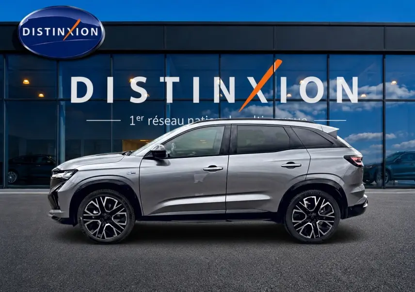 Profil droit du Renault Austral gris schiste 2026 avec jantes alliage et toit noir devant une vitrine Distinxion.