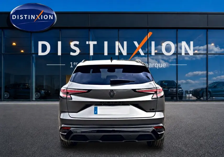 Vue arrière du Renault Austral gris schiste avec feux LED fins et toit noir, stationné devant une vitrine Distinxion.