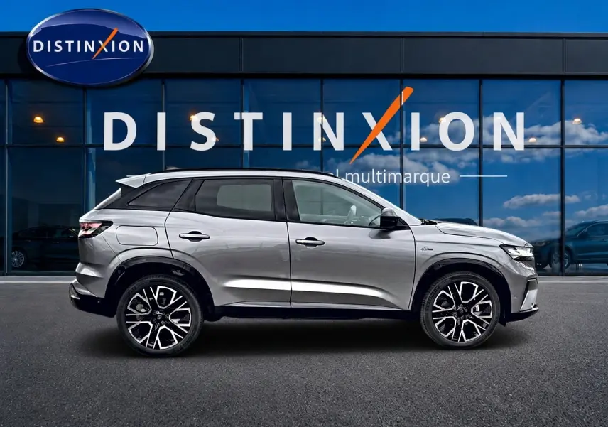 Profil droit du Renault Austral gris schiste 2026, avec jantes alu et toit noir, devant une vitrine Distinxion.