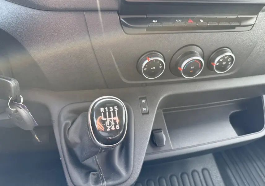 Gros plan sur la boîte manuelle et les commandes de climatisation du tableau de bord du Renault Master blanc de 2020.