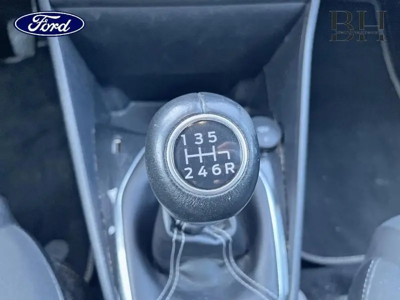 Levier de vitesse cuir en gros plan dans l'habitacle d'une Ford Fiesta gris lunaire, boîte manuelle 6 rapports.