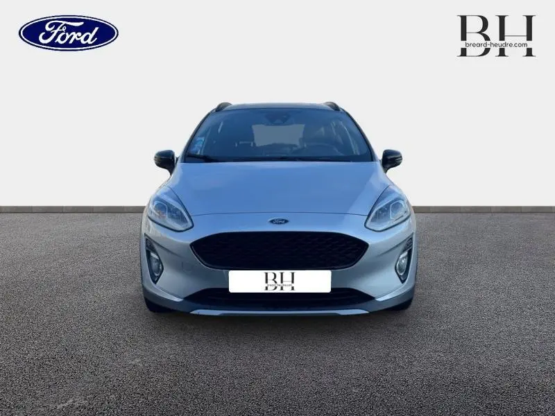 Vue avant d'une Ford Fiesta 1.0 EcoBoost gris lunaire avec calandre noire et phares LED, sur fond neutre.