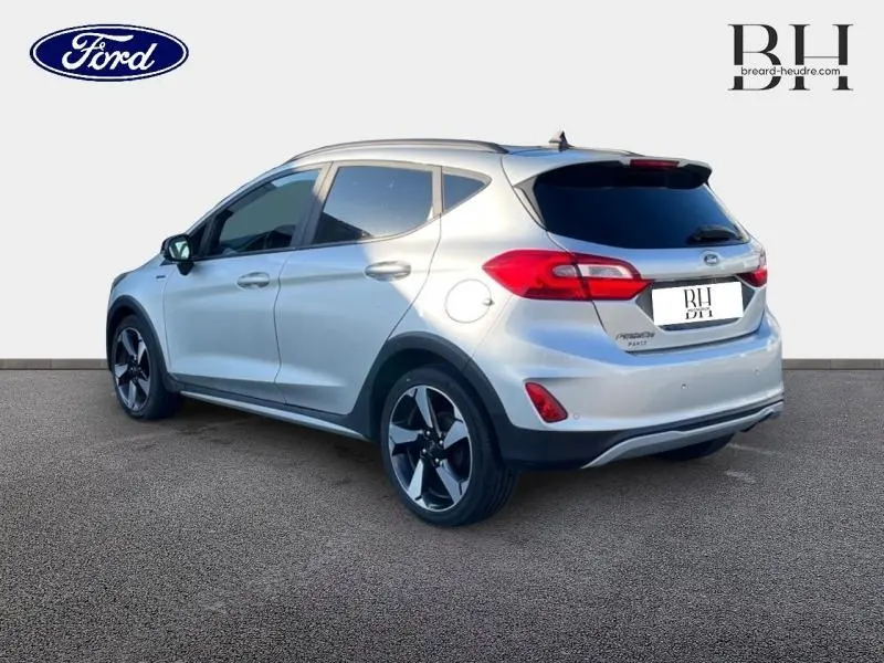 Vue 3/4 arrière droite d'une Ford Fiesta 1.0 EcoBoost gris lunaire avec vitres arrière surteintées et jantes alu noires.
