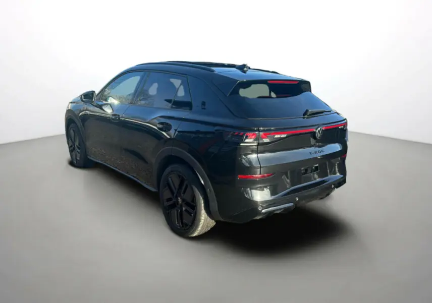 Volkswagen T-Roc noir ebène en 3/4 arrière droit, avec jantes alu noires et feux arrière LED reliés.