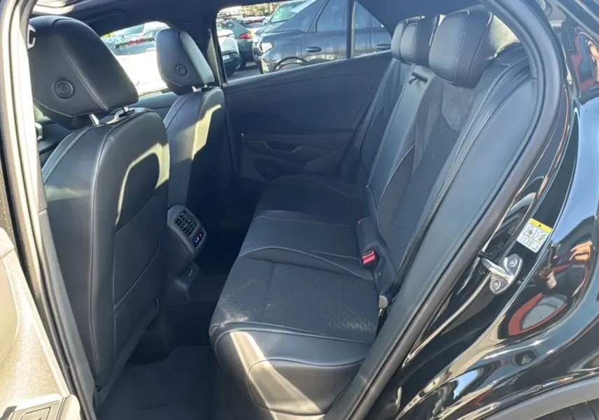 Vue intérieure arrière droite du Volkswagen T-Roc noir ebène, montrant la banquette arrière en tissu et cuir avec appuie-têtes.