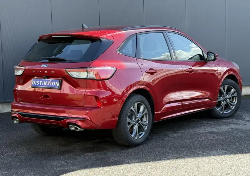 Vue 3/4 arrière droite du Ford Kuga rouge Lucifer 2024 avec double sortie d'échappement et jantes alliage 18 pouces.