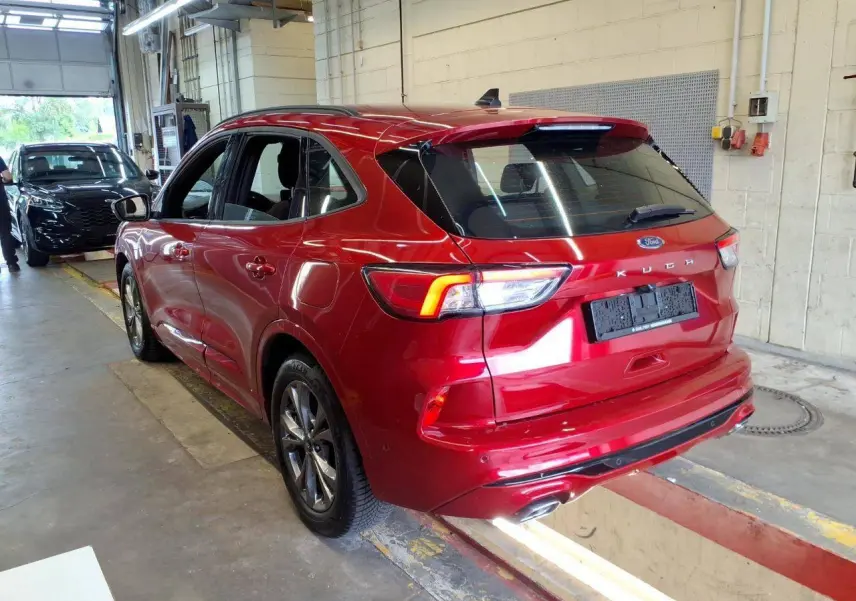 Vue 3/4 arrière droite du Ford Kuga rouge Lucifer 2024 avec jantes alliage et double sortie d’échappement ST-Line.