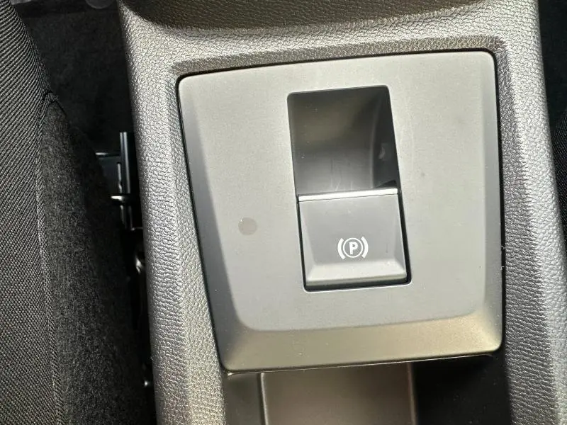 Gros plan sur le bouton de frein de stationnement électronique noir dans l'habitacle du Citroën C3 Aircross 2026.