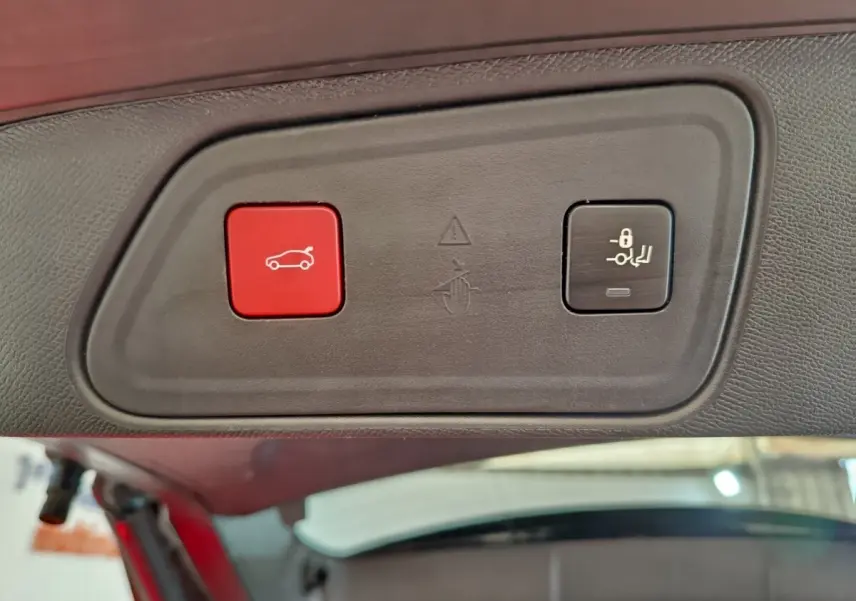 Gros plan sur les boutons d'ouverture et de verrouillage du coffre du Peugeot 3008 bleu, vue intérieure du hayon.