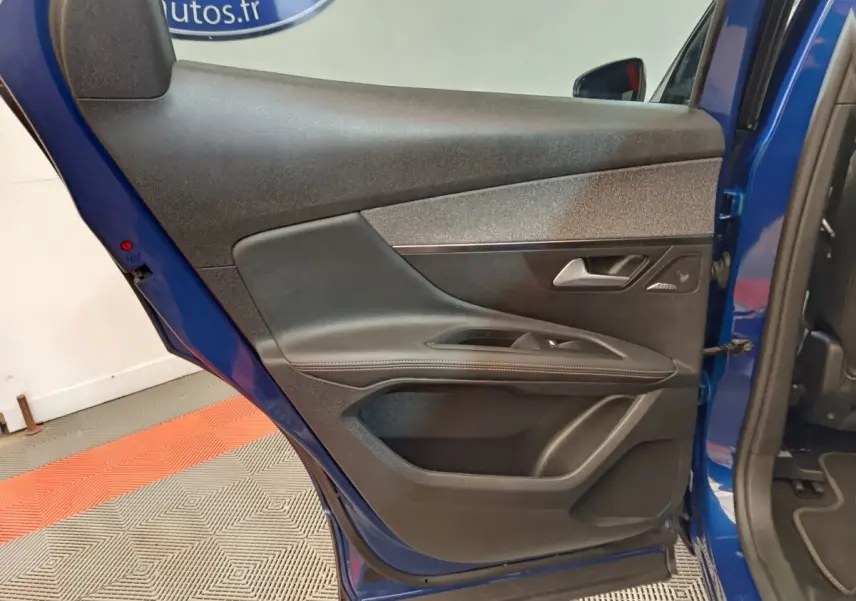 Vue intérieure de la porte arrière droite bleu du Peugeot 3008 1.6 HYBRID 225 GT Pack avec garniture noire et commandes fenêtres.