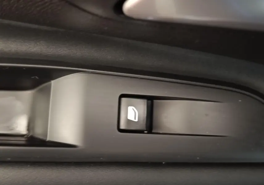 Gros plan sur le bouton de commande de lève-vitre côté conducteur du Peugeot 3008 hybride bleu 2020.