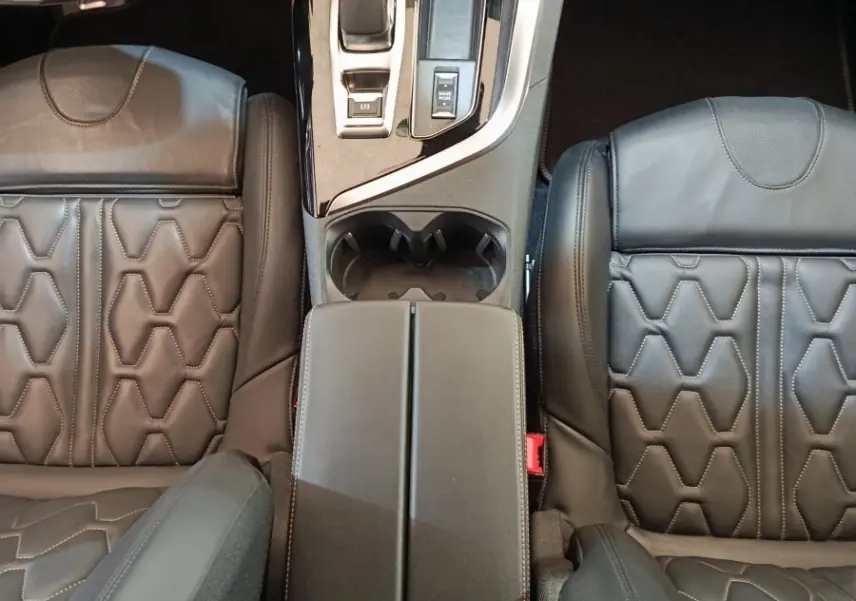 Vue plongeante sur la console centrale et les sièges en cuir noir du Peugeot 3008 Hybrid 225 GT Pack.