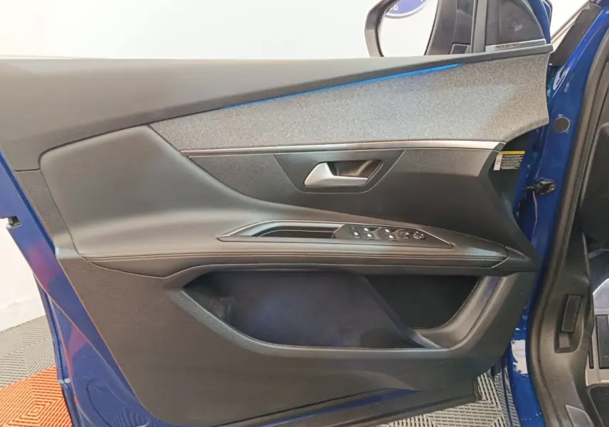 Vue intérieure côté gauche de la porte avant bleue du Peugeot 3008 avec commandes des vitres et poignée argentée.