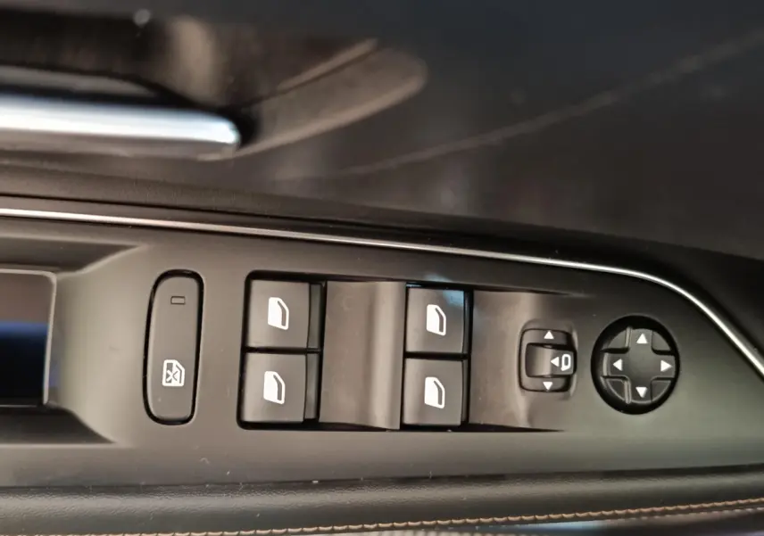 Gros plan sur les commandes de lève-vitres et rétroviseurs côté gauche intérieur d'une Peugeot 3008 bleu hybride rechargeable.