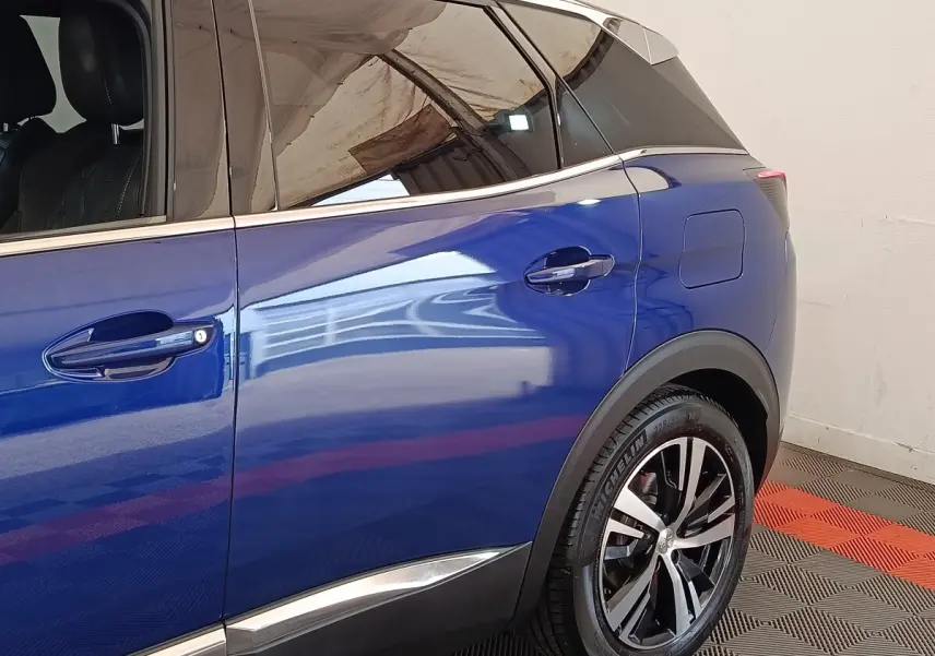 Vue côté droit arrière du Peugeot 3008 bleu hybride rechargeable, mettant en valeur la jante alliage et la trappe de recharge.