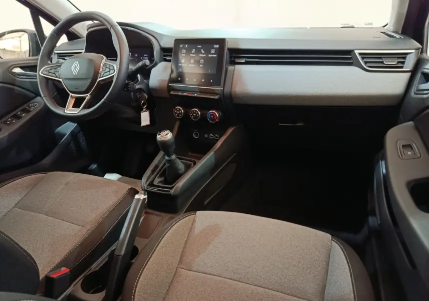 Vue intérieure avant droite de la Renault Clio 2025, tableau de bord moderne avec écran tactile et volant multifonctions.