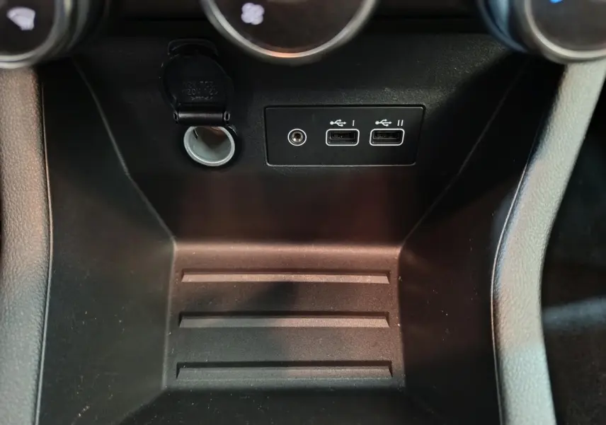 Gros plan sur la console centrale noire de la Renault Clio Evolution Blue dCi 100, montrant prises USB et prise 12V.