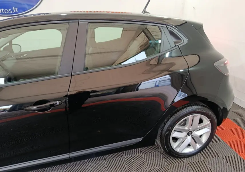Vue latérale droite d'une Renault Clio noire 2025, mettant en valeur la porte arrière et la roue arrière avec jante argentée.