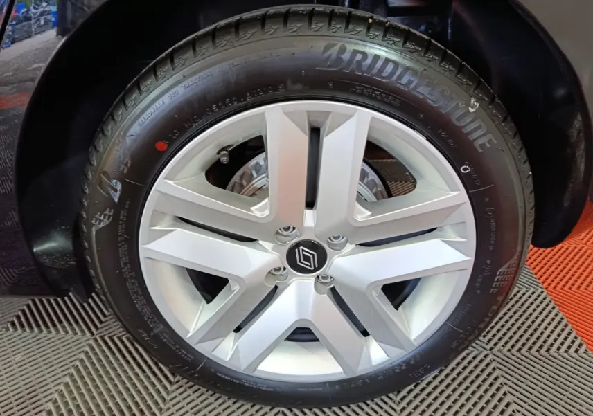 Gros plan sur la roue arrière gauche noire d'une Renault Clio Evolution Blue dCi 100, avec passage de roue visible.