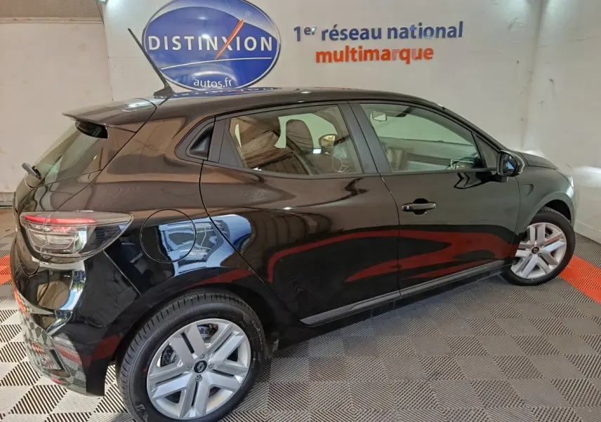 Vue latérale droite d'une Renault Clio noire 2025 garée en intérieur avec jantes argentées et vitres teintées.
