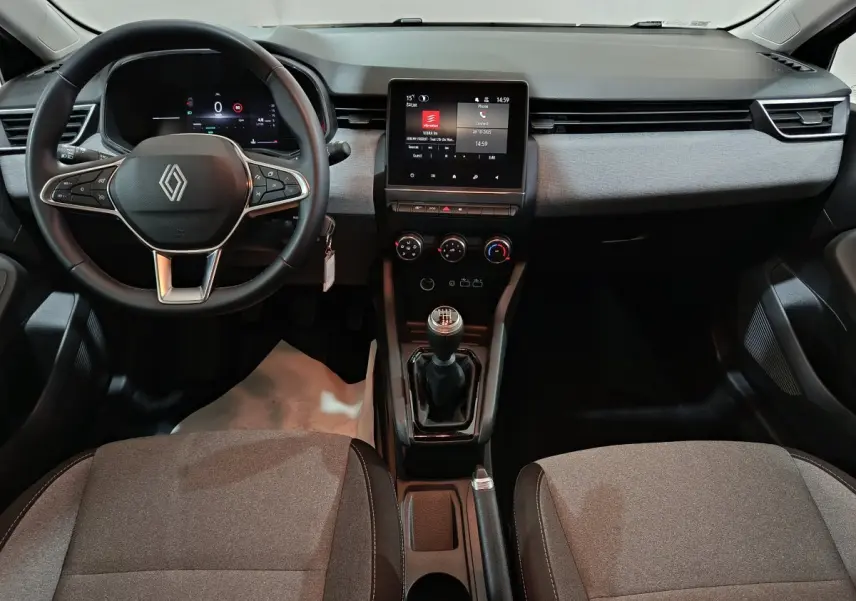 Vue intérieure frontale de la Renault Clio noire 2025 montrant le volant cuir, écran tactile central et levier de vitesse manuel.