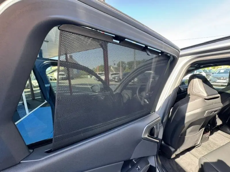 Vue intérieure côté arrière droit d’un BMW X3 xDrive20 2024 avec pare-soleil en filet et sièges sport Alcantara noirs.