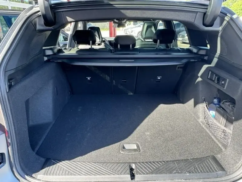 Vue du coffre ouvert d'un BMW X3 xDrive20 2024 en BMW Ind Frozen Pure Grey, montrant l'espace de chargement et banquette arrière.
