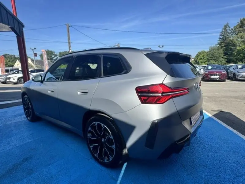 BMW X3 xDrive20 2024 en BMW Ind Frozen Pure Grey, vue 3/4 arrière droit avec feux arrière LED et jantes noires.