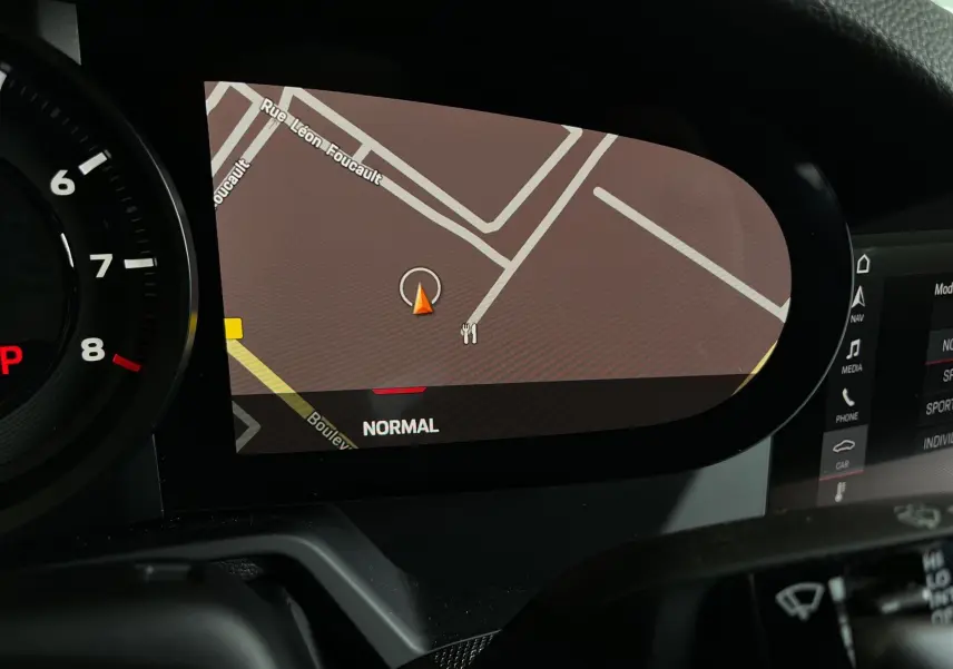 Affichage du GPS sur le tableau de bord numérique d'une Porsche 911 992 argent, vue intérieure rapprochée.